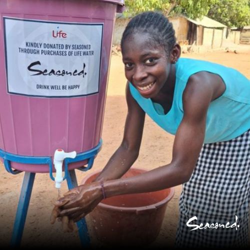 Girl in a village cleaning her hands from a clean water tap